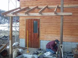 attach a little roof to the east side wall of the hut